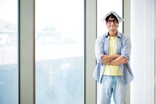 Giovane studente bello in piedi alla finestra — Foto Stock