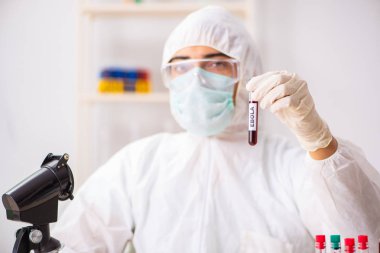 Genç yakışıklı laboratuvar asistanı hastanede kan örnekleri test ediyor. 