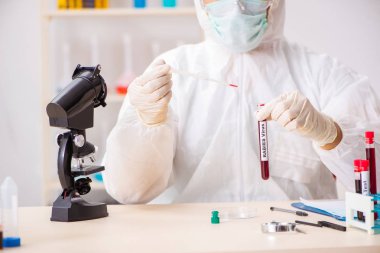 Genç yakışıklı laboratuvar asistanı hastanede kan örnekleri test ediyor. 