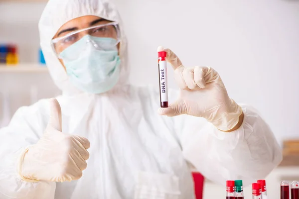 Asistente de laboratorio joven guapo analizando muestras de sangre en el hospital — Foto de Stock