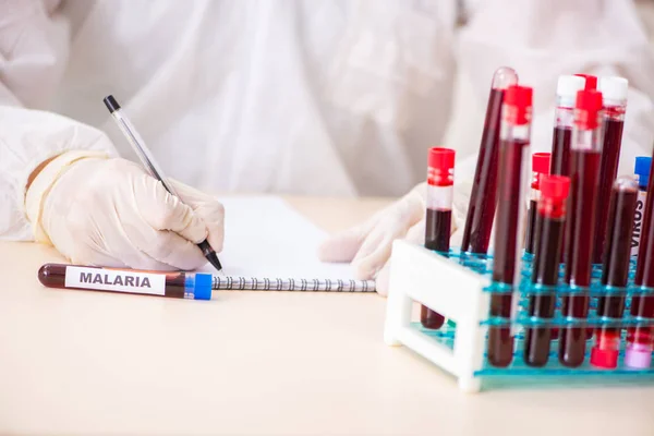 Asistente de laboratorio joven guapo analizando muestras de sangre en el hospital —  Fotos de Stock