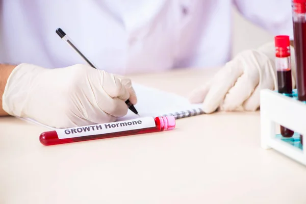 Asistente de laboratorio joven guapo analizando muestras de sangre en el hospital — Foto de Stock