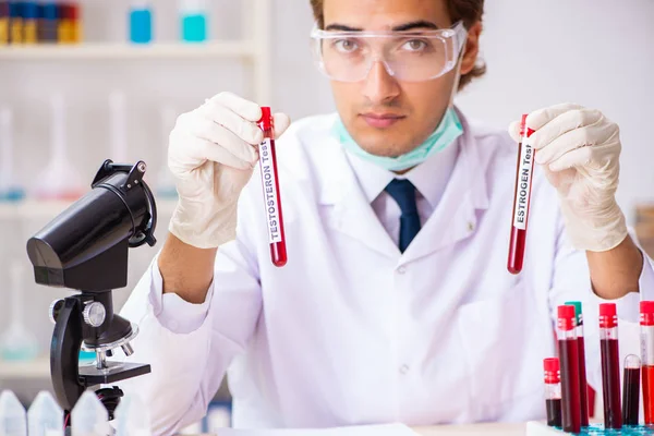 Jovem assistente de laboratório bonito testando amostras de sangue no hospital — Fotografia de Stock