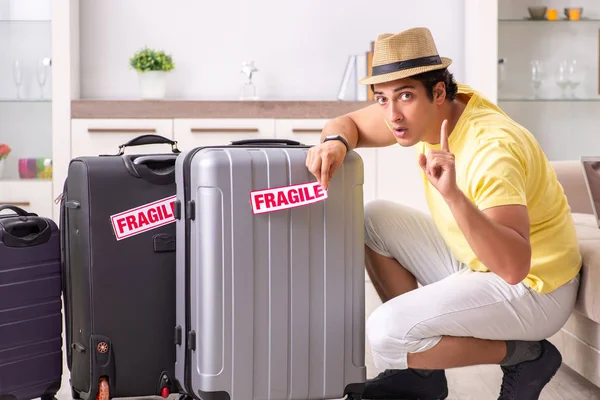 Muž jede na dovolenou s křehkými kufry — Stock fotografie