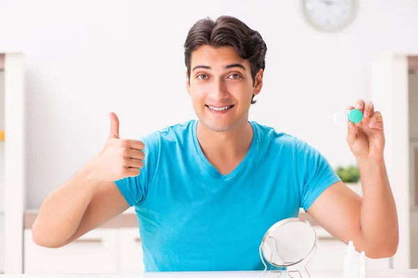 Homem tentando lentes de contato em casa — Fotografia de Stock