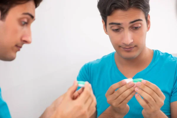 Homem tentando lentes de contato em casa — Fotografia de Stock