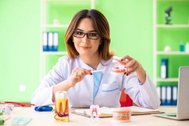 Diş implantı üzerinde çalışan kadın dişçi.