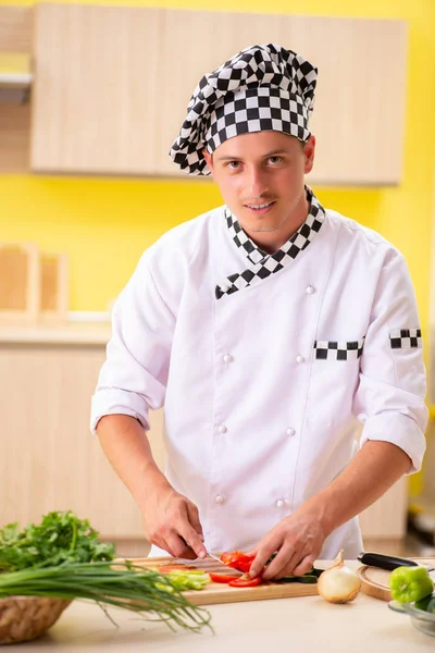 Młody profesjonalny kucharz przygotowanie sałatki w kuchni — Zdjęcie stockowe