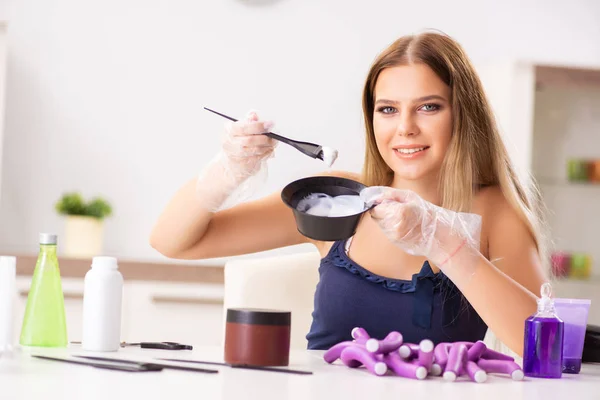 Jeune femme avec des bigoudis au salon de coiffure — Photo