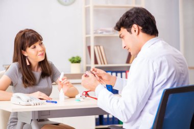 Genç bir kadın, erkek doktor göz doktorunu hastanede ziyaret ediyor.