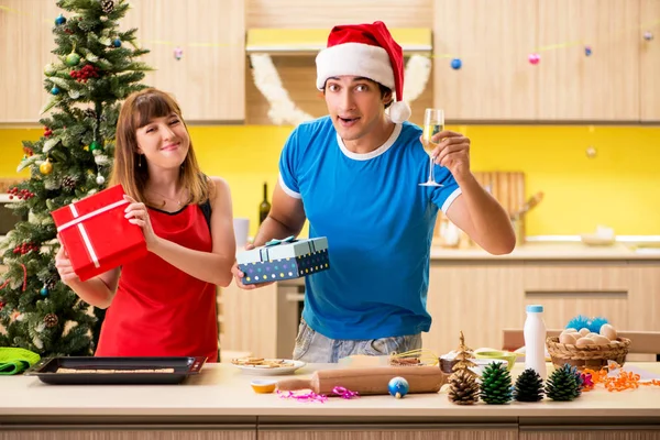 Young couple celebrating Christmas in kitchen — Stock Photo, Image