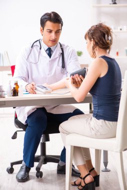 Genç doktor, kadınların tansiyonunu ölçüyor.