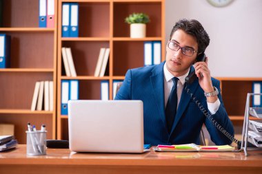 Genç yakışıklı işadamı ofiste çalışıyor.