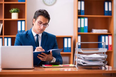 Genç yakışıklı işadamı ofiste çalışıyor.