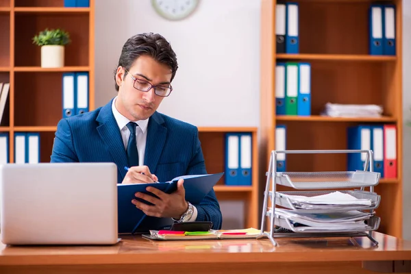 Genç yakışıklı işadamı ofiste çalışıyor.