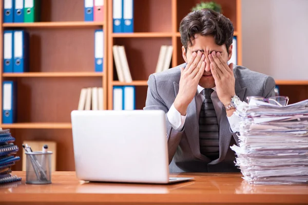 Joven hombre de negocios guapo infeliz con el trabajo excesivo — Foto de Stock