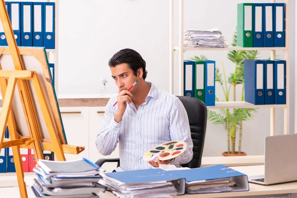 Молодой красивый работник наслаждается живописью в офисе — стоковое фото