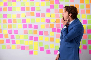 Çelişkili öncelikler konseptinde genç yakışıklı bir adam