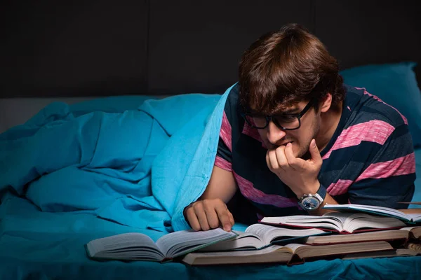 Молодой студент готовится к экзаменам ночью дома — стоковое фото