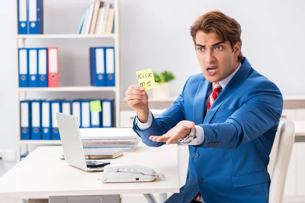 Office prank with kick me message on sticky note