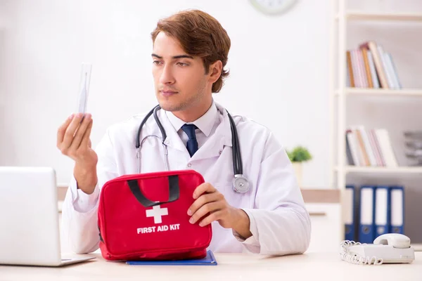 Junger Arzt mit Verbandskasten im Krankenhaus — Stockfoto