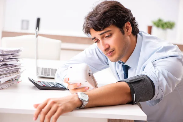 Hombre bajo estrés midiendo su presión arterial — Foto de Stock