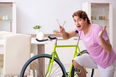 Kırık bisikletini tamir eden adam.