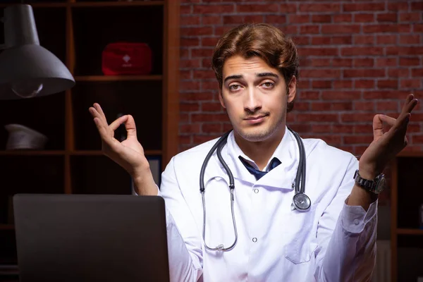 Joven médico guapo trabajando de noche en el hospital —  Fotos de Stock