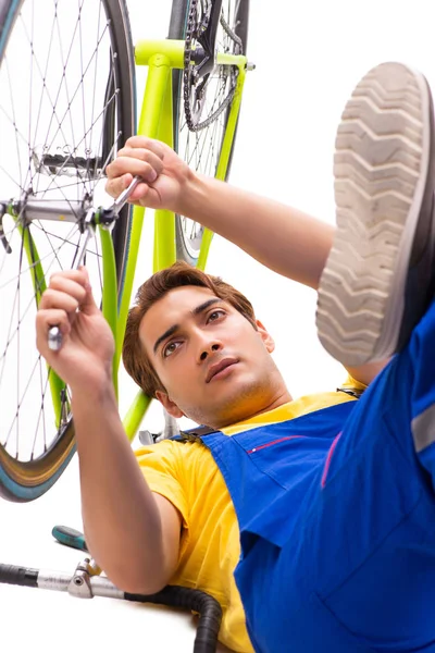 Homem reparando sua bicicleta isolada no fundo branco — Fotografia de Stock