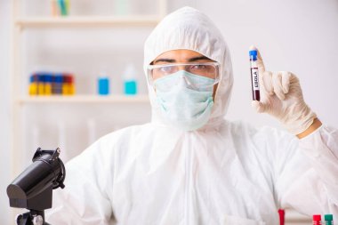 Genç yakışıklı laboratuvar asistanı hastanede kan örnekleri test ediyor. 
