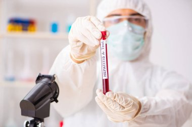 Genç yakışıklı laboratuvar asistanı hastanede kan örnekleri test ediyor. 