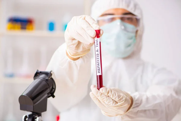 Asistente de laboratorio joven guapo analizando muestras de sangre en el hospital —  Fotos de Stock