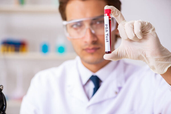Young handsome lab assistant testing blood samples in hospital 