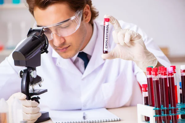 Genç yakışıklı laboratuvar asistanı hastanede kan örnekleri test ediyor. 