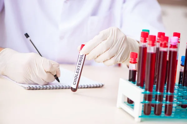 Fiatal jóképű laboratóriumi asszisztens vérmintákat tesztel a kórházban — Stock Fotó