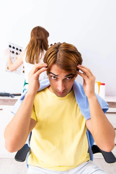 Peluquero mujer aplicando tinte al cabello del hombre — Foto de Stock