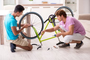 Kırık bisikletini tamir eden adam.