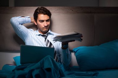 Yorgun işadamı gece fazla mesai yapıyor.