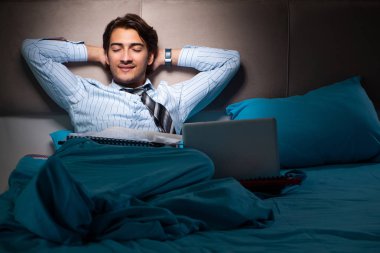 Yorgun işadamı gece fazla mesai yapıyor.
