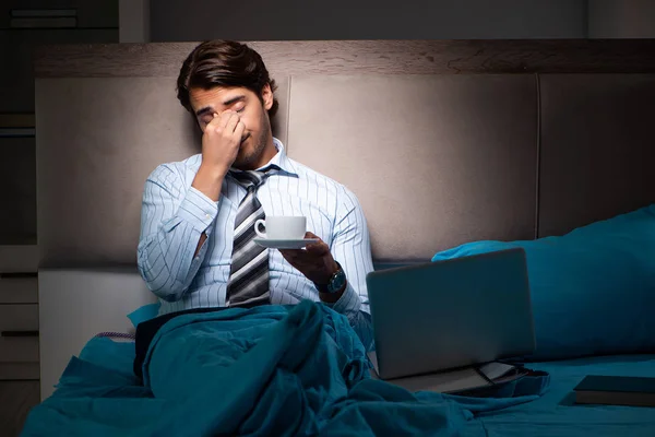 Tired businessman working overtime at home at night