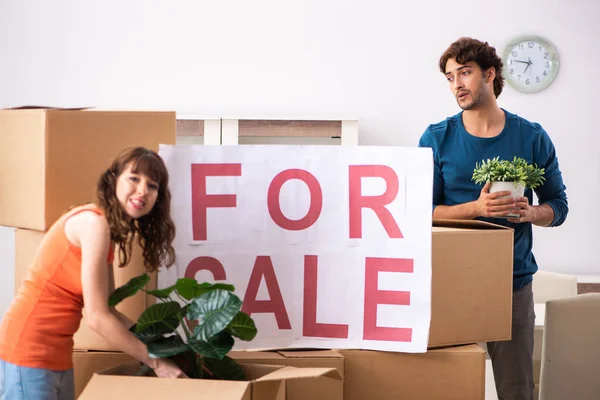 Joven familia ofreciendo casa para la venta y mudanza — Foto de Stock