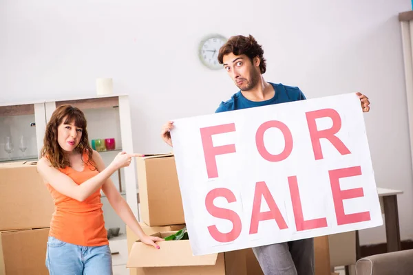 Joven familia ofreciendo casa para la venta y mudanza — Foto de Stock