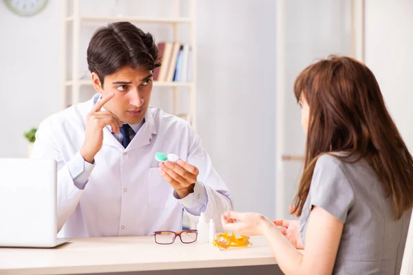 Mujer joven que visita al oftalmólogo médico masculino en el hospital —  Fotos de Stock