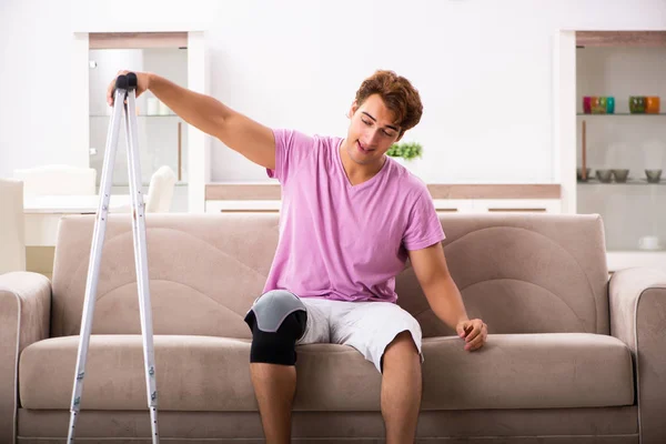 Junger Mann mit verletztem Knie erholt sich zu Hause — Stockfoto