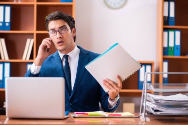 Genç yakışıklı işadamı ofiste çalışıyor.