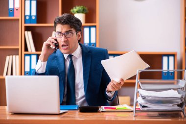 Genç yakışıklı işadamı ofiste çalışıyor.