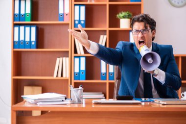 Genç yakışıklı işadamı ofiste çalışıyor.