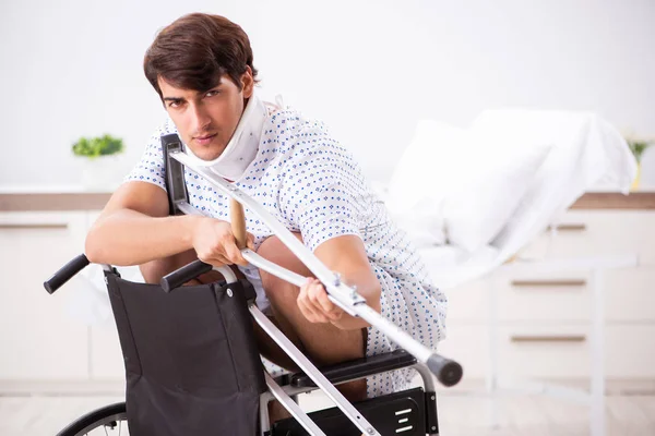Молодой красивый мужчина в инвалидной коляске в больнице — стоковое фото