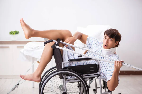 Junger schöner Mann im Rollstuhl im Krankenhaus — Stockfoto