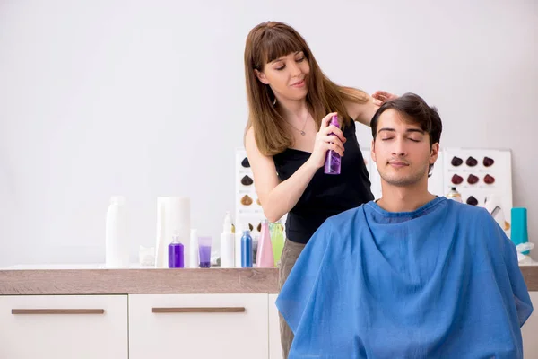 Jovens atraem homem visitando barbeiro feminino — Fotografia de Stock